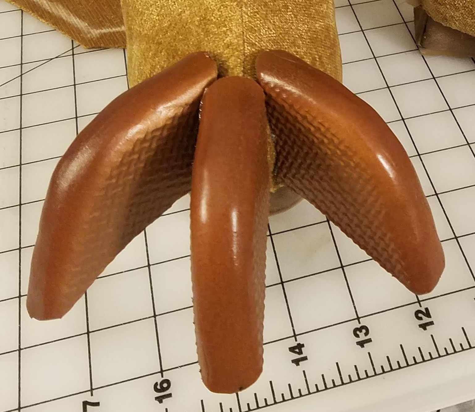alt: Finished costume components, including tail, shoe covers, and bracers.